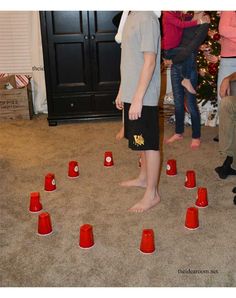 a young boy standing in front of a christmas tree surrounded by orange cones on the floor