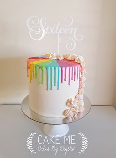 a white cake with rainbow icing on top