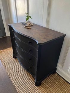 a black dresser sitting on top of a wooden floor