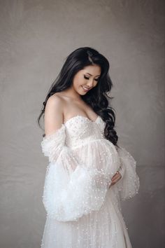 a woman in a white dress posing for the camera with her hands on her hips