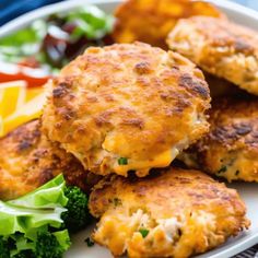 some crab cakes are on a plate with broccoli