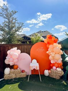 an outdoor area with balloons and decorations on the ground, including two heart shaped chairs