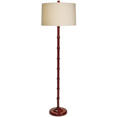 a floor lamp with a white shade on it's base and a red wooden base