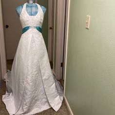 a wedding dress is displayed on a mannequin in front of a door way