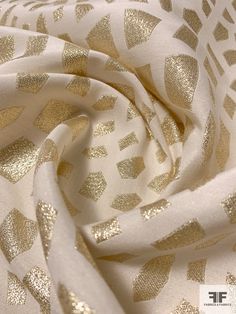 A spectacular glittery designer fashion fabric, this is a metallic geometric brocade in gold and off-white. SKU: 7441 Content: Poly / Lurex Color: Gold / Off-White Width: 54 inches This fabric is a last cut and no longer in production. Once sold out, we are unable to get more. Elegant Cream Fabric For Party, Cream Elegant Party Fabric, Elegant White Fabric For Festive Season, Elegant White Festive Fabric, Festive Cream Elegant Fabric, Festive Jacquard Fabric For Party, Elegant Gold Fabric For Formal Occasions, Festive Party Jacquard Fabric, Gold Fabric For Formal Festive Occasion