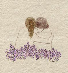 two people hugging each other with purple flowers in the foreground and white paper behind them