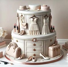 a wedding cake is decorated with white and gold accessories, including shoes, handbags, purses, and dresses