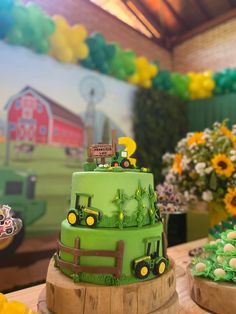 there is a green cake with farm animals on it and flowers in the back ground