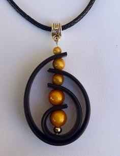 a black leather necklace with yellow beads hanging from it's center circle, on a white background