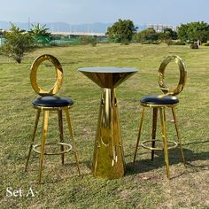 two stools and a table in the grass