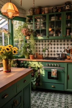 a kitchen with green cabinets and sunflowers on the counter top in front of an oven