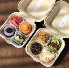 three plastic containers filled with different types of pastries and desserts on top of a wooden table