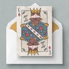 a card with an image of a king and queen in the middle, on top of a white envelope