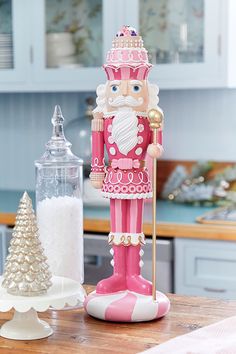 a nutcracker figurine sitting on top of a table next to a candle