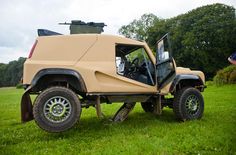 an off - road vehicle parked in the grass with its doors open