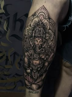 an elephant tattoo on the leg of a man's leg, which is covered in black and grey ink