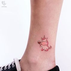 a small unicorn tattoo with a glass of wine on the ankle and an eyeglass