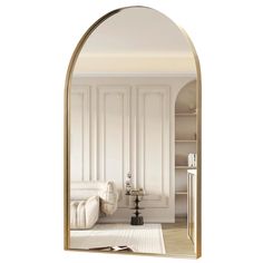 an arch shaped mirror in the middle of a room with a white couch and bookcase