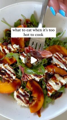 a white plate topped with peaches and feta cheese on top of lettuce