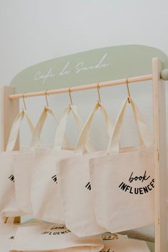 tote bags are hanging on a rack