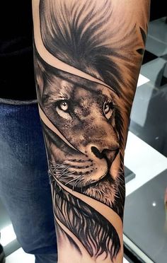 a man's arm with a lion tattoo on it and an arrow in the middle