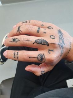 a person with tattoos on their fingers and hand