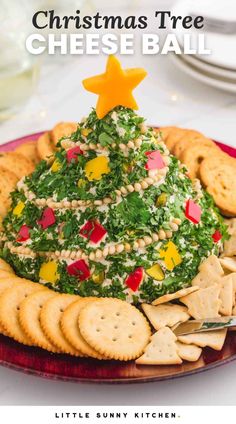 a christmas tree cheese ball on a plate with crackers