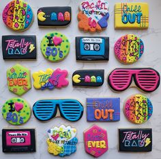 many decorated cookies are arranged on a table with sunglasses and other items in the background