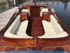 the inside of a wooden boat docked at a dock with other boats in the water