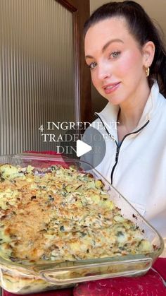 a woman is holding up a casserole dish