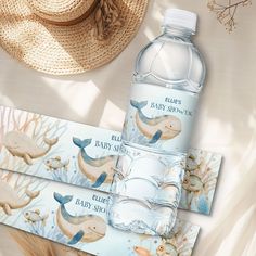 two water bottles with labels on them sitting next to hats and straw hat, along with other items