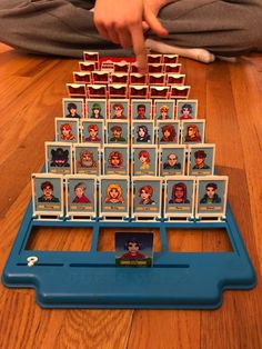 a person sitting on the floor next to a wooden table with many cards in front of them