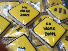 yellow and black decorated cookies with no work zone written on them are wrapped in plastic