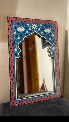 a mirror sitting on top of a table next to a wall