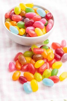 a bowl filled with jelly beans on top of a table