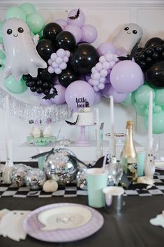 a table topped with lots of balloons and decorations