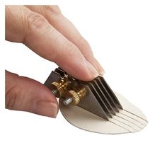 a person holding a small metal object in their right hand and pulling it out from the other