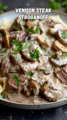 a close up of a plate of food with meat and mushrooms in gravy