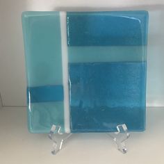 a blue and white glass plate sitting on top of a counter next to a wall