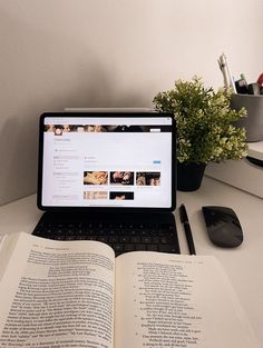 an open book sitting on top of a laptop computer next to a mouse and keyboard