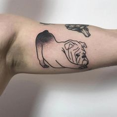 a man's arm with a dog tattoo on the left side of his arm