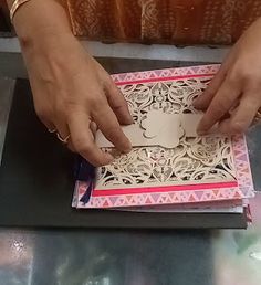 a woman is cutting out a card with scissors and glue on the inside of it