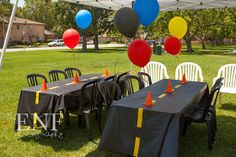 an outdoor party setup with balloons and tables