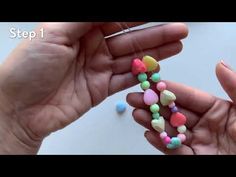 two hands are holding small candy beads