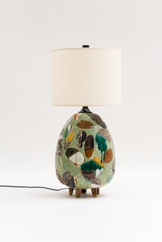 a lamp that is sitting on top of a white surface with a green and yellow design