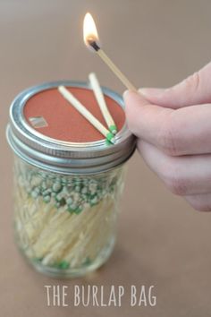 a person lighting a match between two matches in a jar filled with noodles and peas