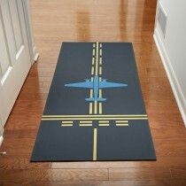 a blue and yellow area rug with an airplane on the ground in front of a door