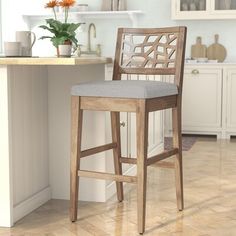 a wooden bar stool sitting on top of a hard wood floor next to a counter