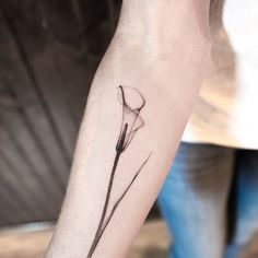 a single flower tattoo on the left arm