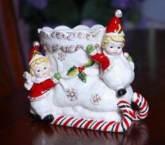 a ceramic figurine sitting on top of a table next to candy canes